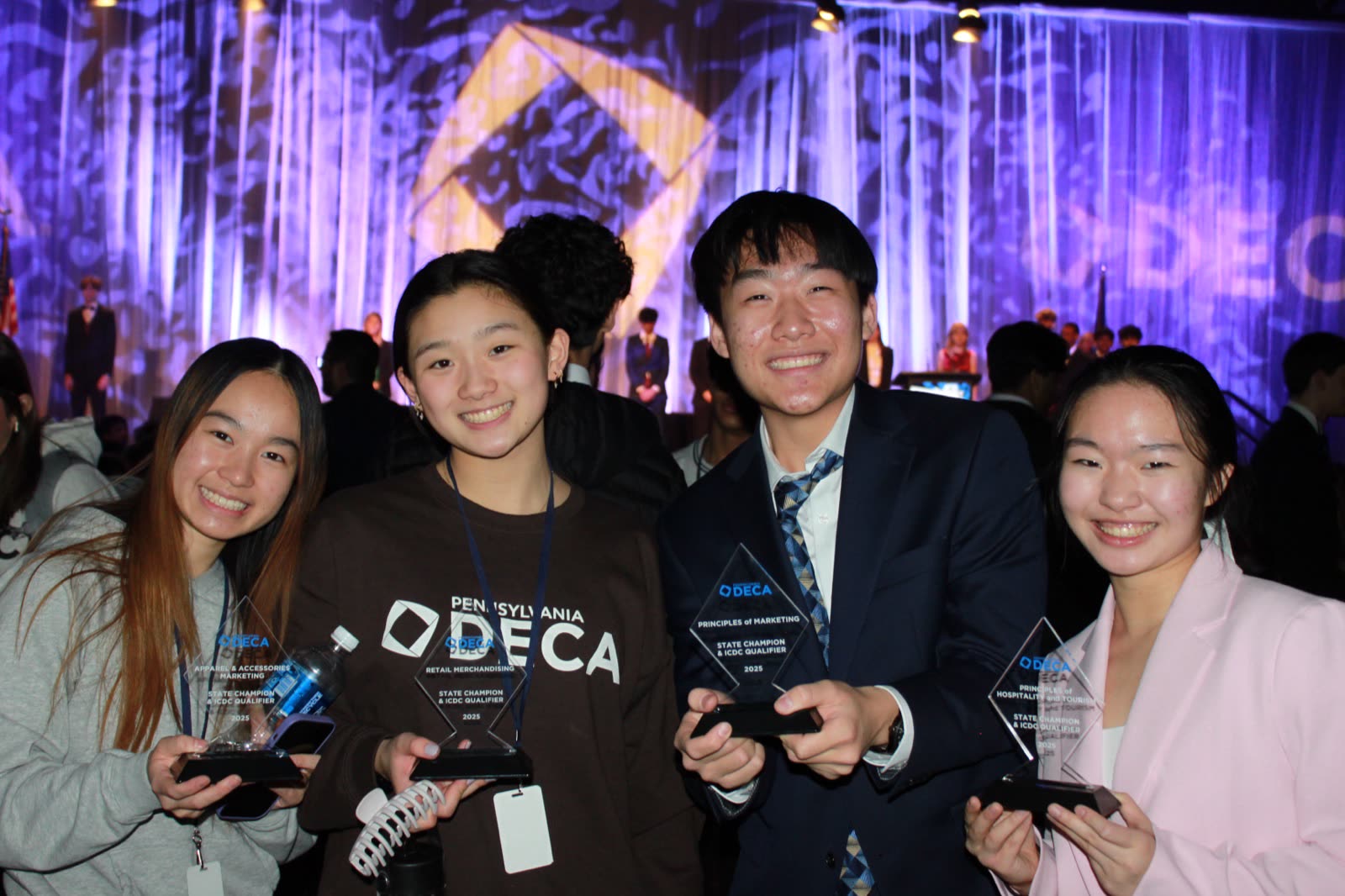 David Mao with three North Allegheny DECA teammates holding 2025 Pennsylvania DECA State Champion trophies